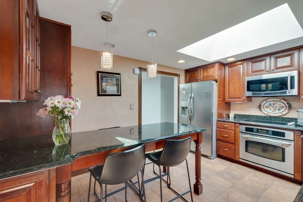 4 Worcester Road Sharon, MA 02067 - Photo 11 of 25 a kitchen with stainless steel appliances kitchen island granite countertop a refrigerator and a stove top oven
