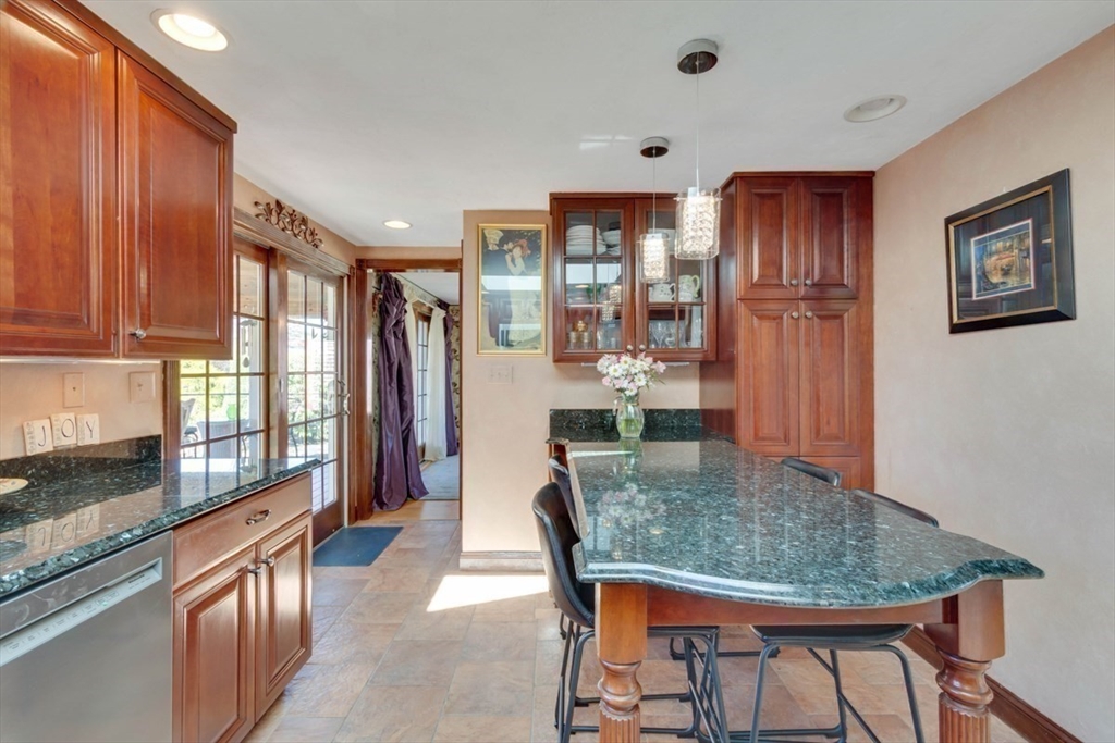 4 Worcester Road Sharon, MA 02067 - Photo 12 of 25 a kitchen with stainless steel appliances granite countertop a refrigerator a stove top oven and a dining table with wooden floor