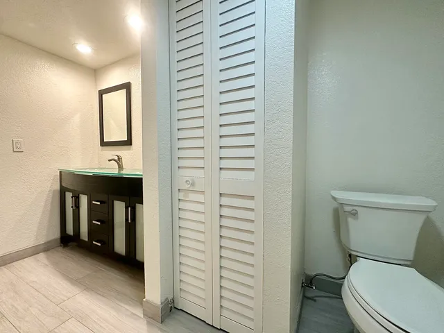 a bathroom with a toilet a sink and mirror
