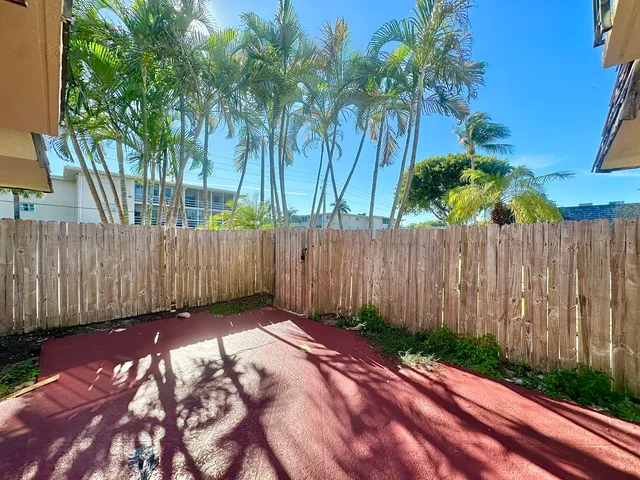 a view of backyard with wooden fence