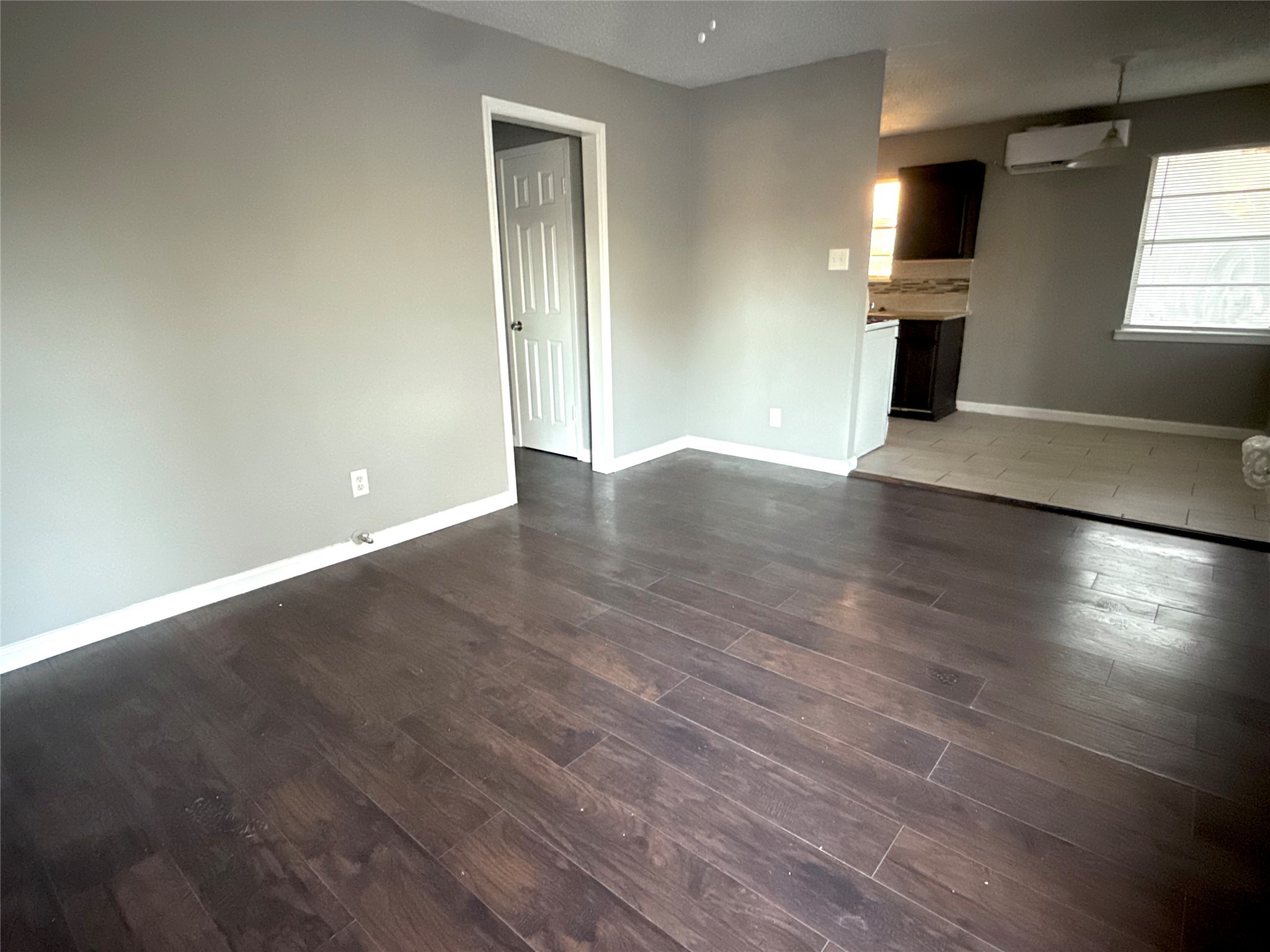 5418 Weaver Road, Unit D Houston, TX 77016 - Photo 3 of 12 an empty room with wooden floor fireplace and windows