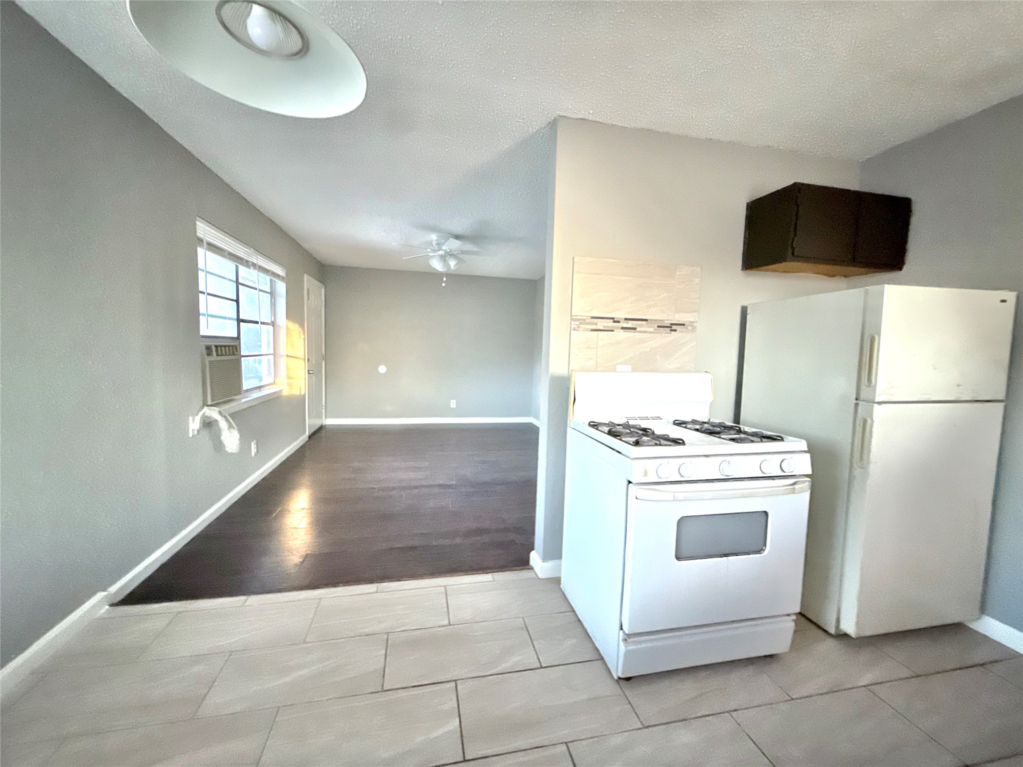 5418 Weaver Road, Unit D Houston, TX 77016 - Photo 5 of 12 a kitchen with a stove a refrigerator and a microwave