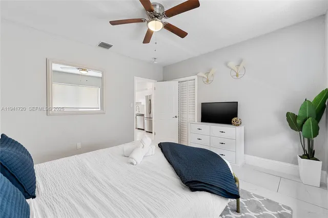 a bedroom with a bed a flat screen tv and a window