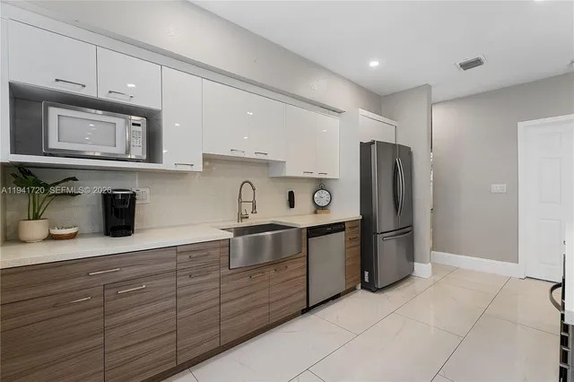 a kitchen with stainless steel appliances granite countertop a refrigerator and a sink