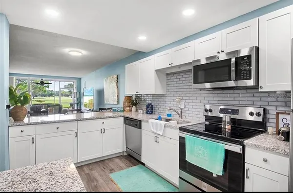 a kitchen with stainless steel appliances granite countertop a sink and cabinets