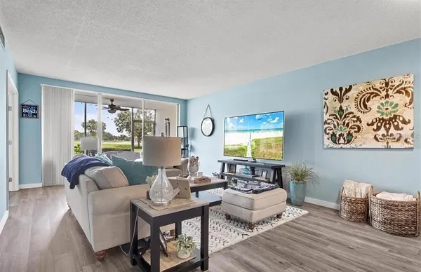 a living room with furniture flat screen tv and a large window