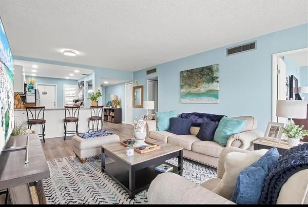 a living room with patio furniture and a garden