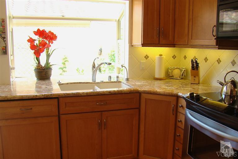 19515 Rinaldi Street, Unit 54 Northridge, CA 91326 - Photo 6 of 20 a kitchen with granite countertop a sink stainless steel appliances and cabinets