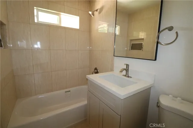 a bathroom with a sink toilet vanity and bathtub