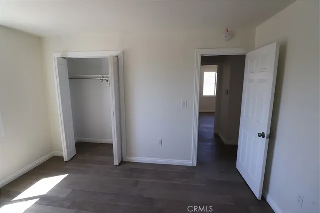 an empty room with closet and a bathroom