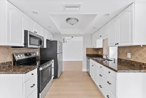 a kitchen with granite countertop a stove sink and cabinets