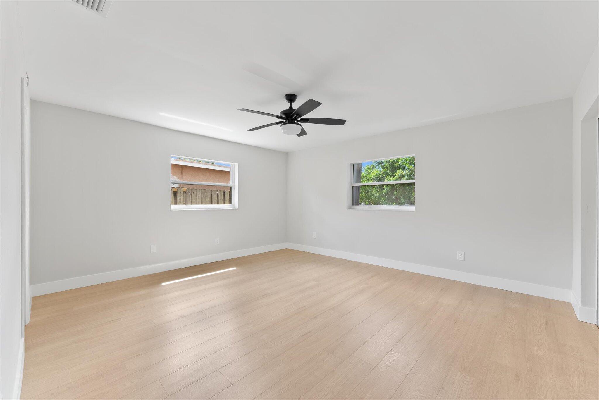 22267 Southwest 57th Avenue Boca Raton, FL 33428 - Photo 18 of 30 an empty room with windows and ceiling fan
