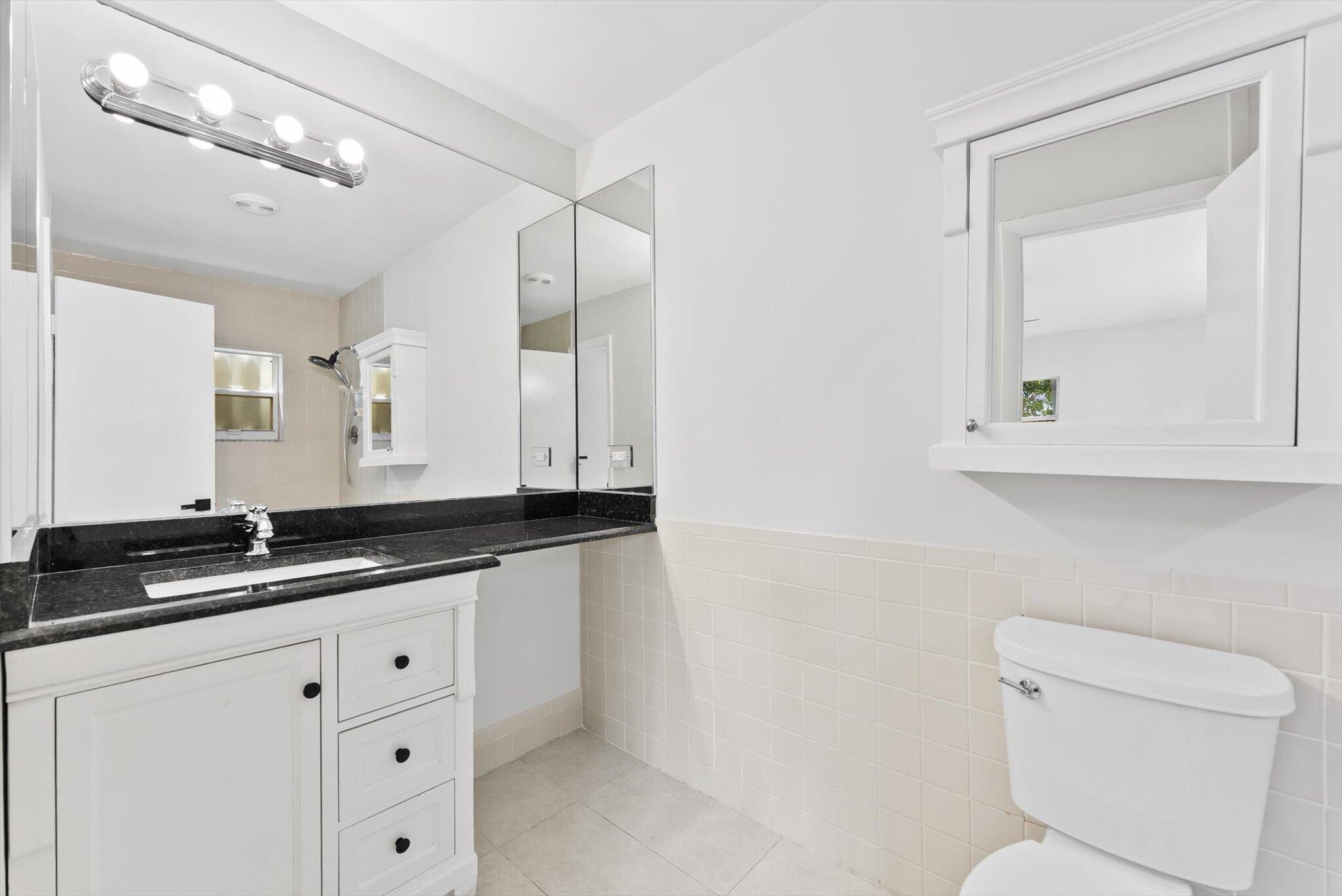 22267 Southwest 57th Avenue Boca Raton, FL 33428 - Photo 19 of 30 a bathroom with a granite countertop sink mirror and toilet