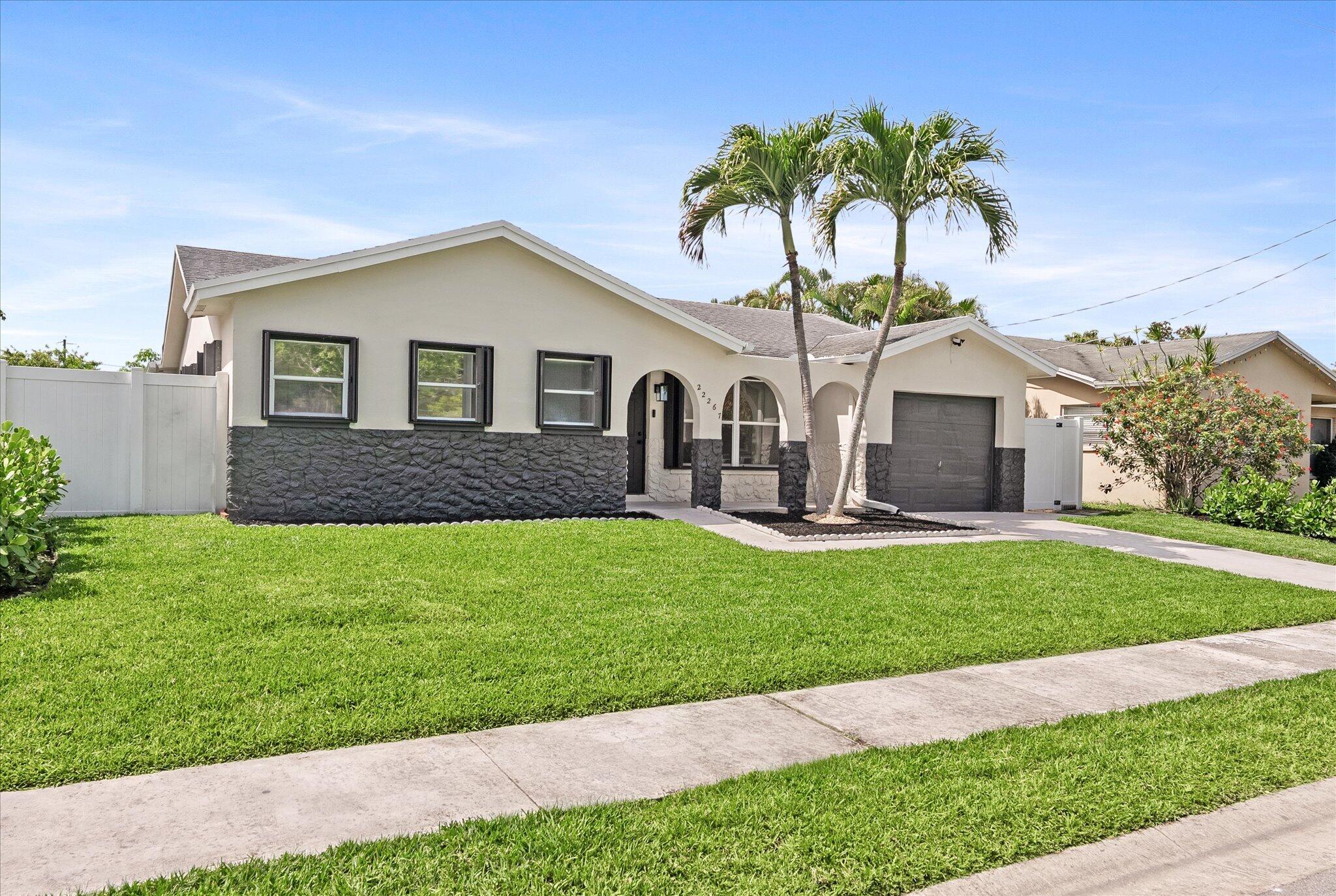22267 Southwest 57th Avenue Boca Raton, FL 33428 - Photo 2 of 30 a front view of a house with a garden and plants
