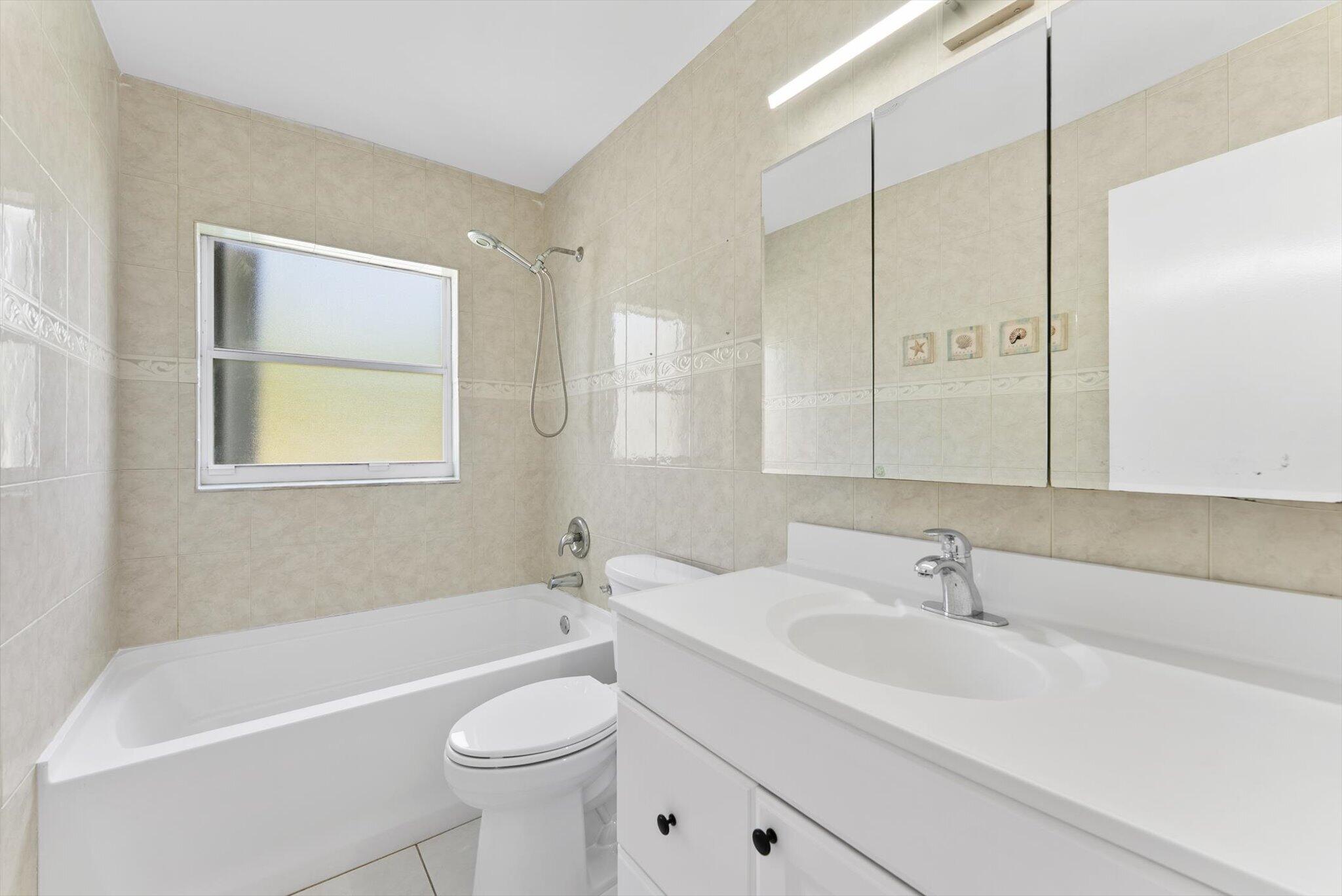 22267 Southwest 57th Avenue Boca Raton, FL 33428 - Photo 22 of 30 a bathroom with a sink a toilet and a bathtub