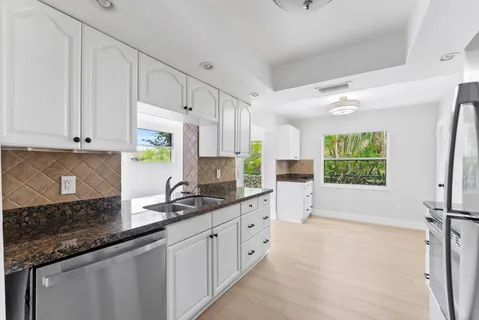 a kitchen with stainless steel appliances granite countertop a sink stove and cabinets