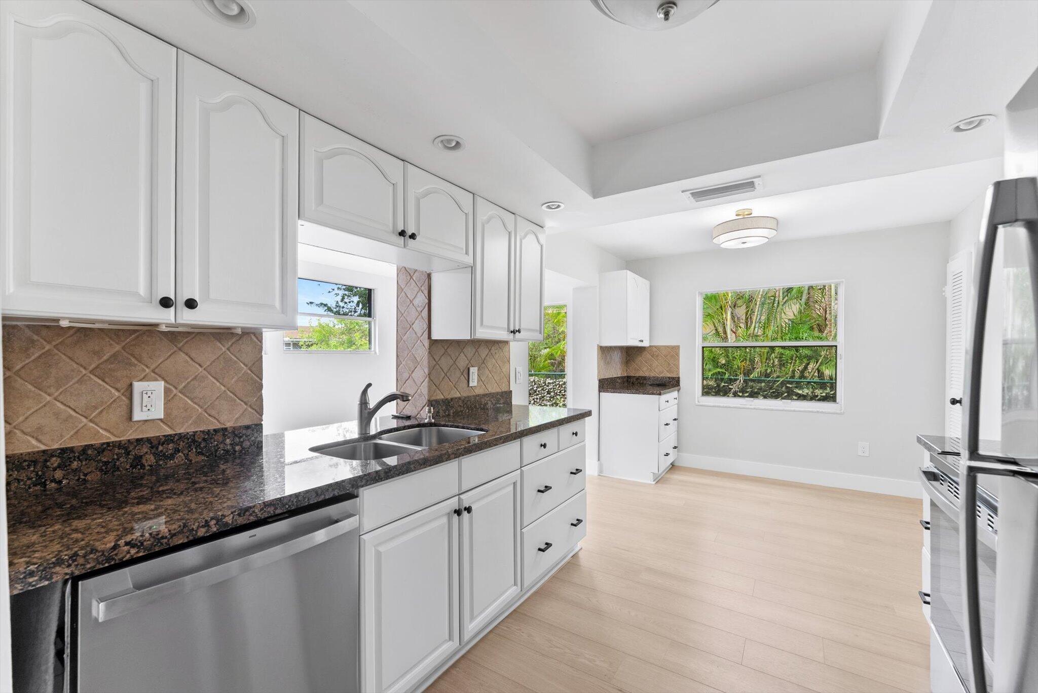 22267 Southwest 57th Avenue Boca Raton, FL 33428 - Photo 10 of 30 a kitchen with stainless steel appliances granite countertop a sink stove and cabinets