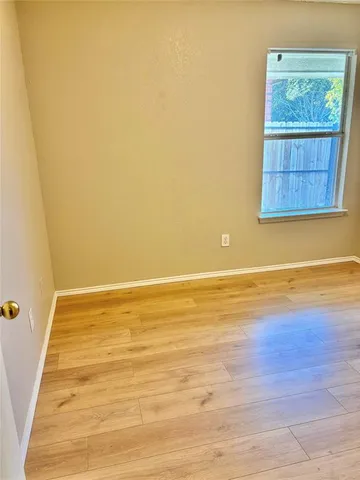 a view of an empty room and wooden floor