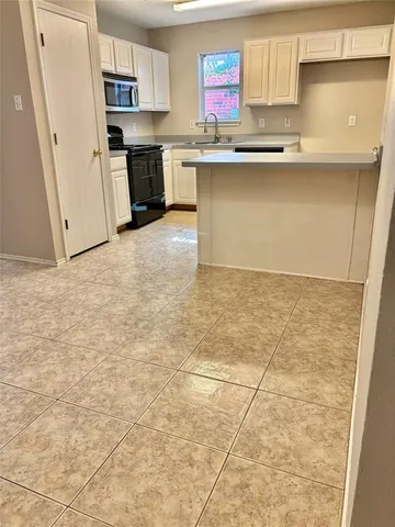 a kitchen with kitchen island granite countertop a stove a sink and a refrigerator