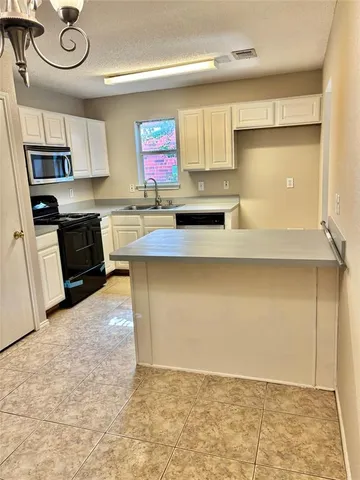 a kitchen with stainless steel appliances granite countertop a sink a stove top oven a counter space and cabinets