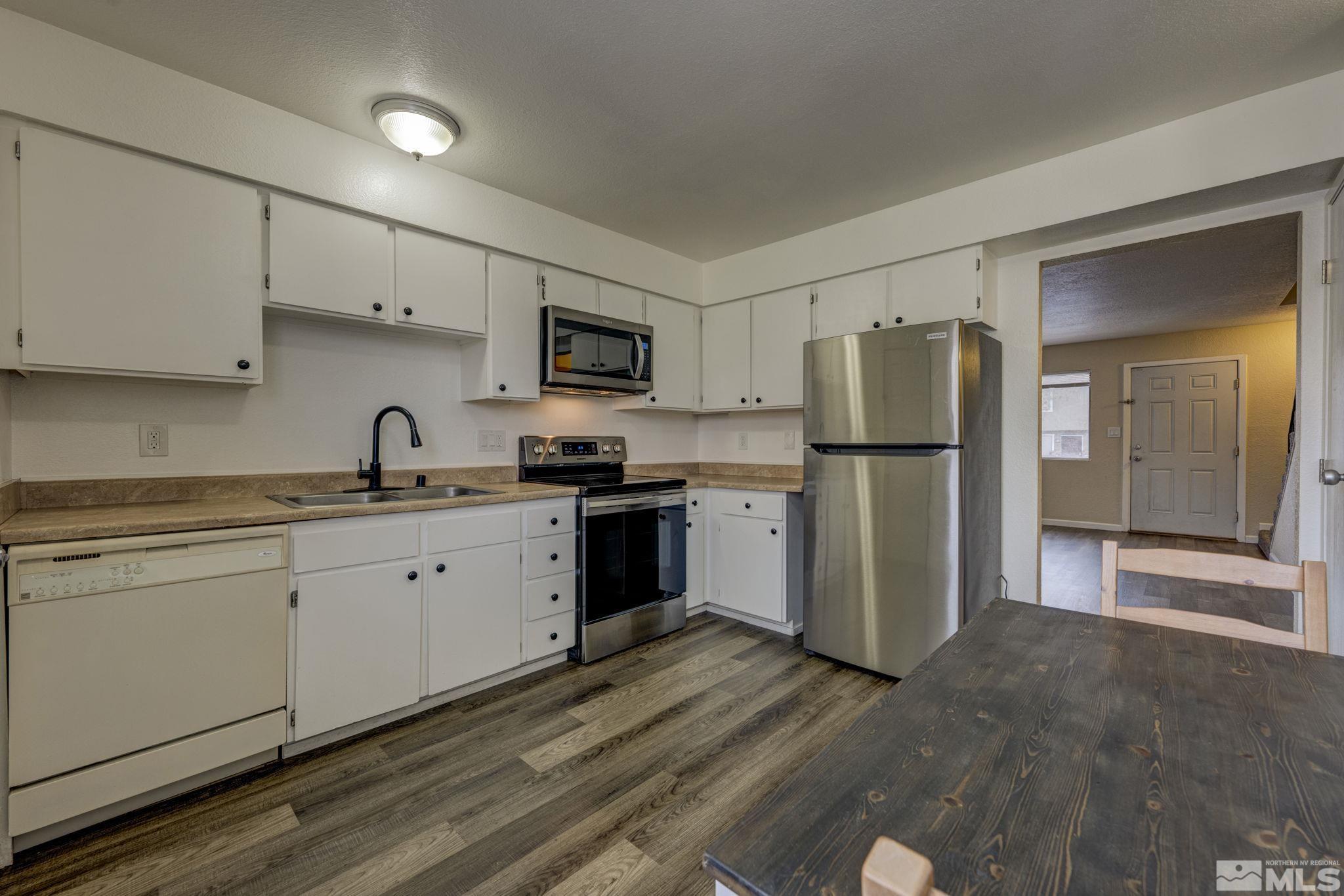 1424 East 9th Street, Unit 3 Reno, NV 89512 - Photo 6 of 26 a kitchen with a refrigerator a stove top oven a sink and cabinets