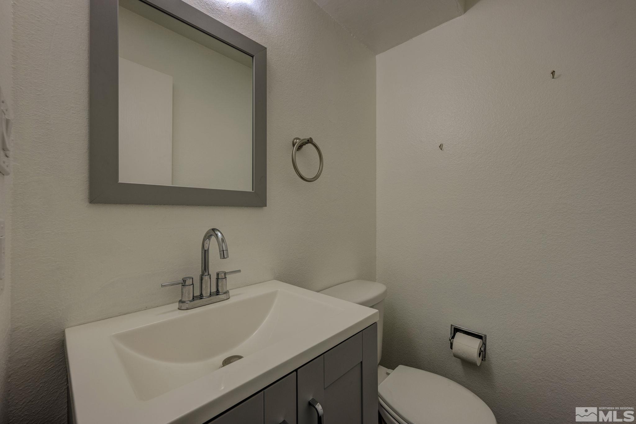 1424 East 9th Street, Unit 3 Reno, NV 89512 - Photo 9 of 26 a bathroom with a toilet a sink and mirror