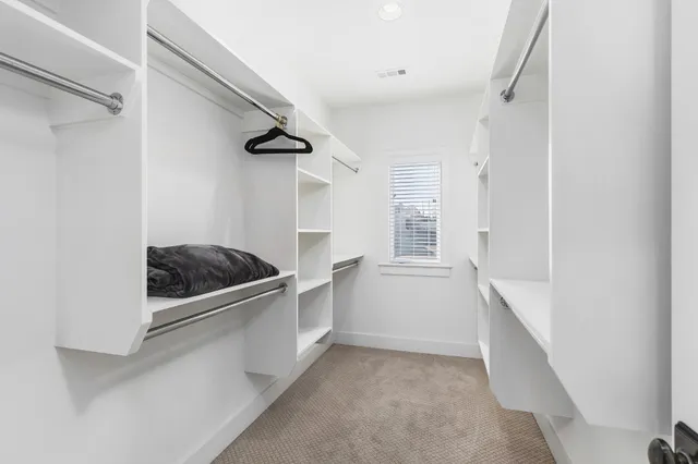 a kitchen with a refrigerator and white cabinets