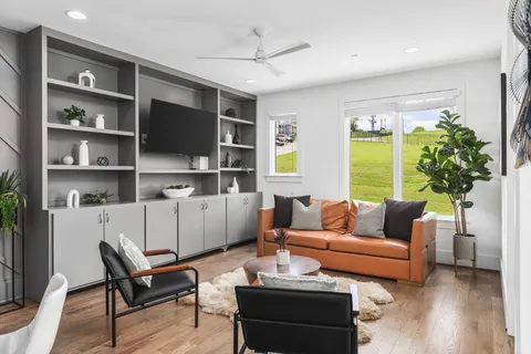 a living room with furniture a flat screen tv and a large window