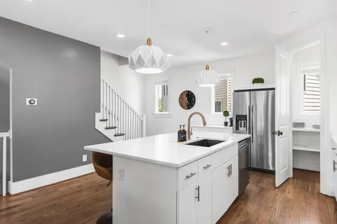 a kitchen with a sink a refrigerator and cabinets