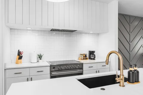 a kitchen with a sink a stove and cabinets