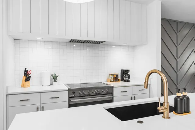 a kitchen with a sink a stove and cabinets