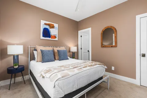 a bedroom with a bed and a painting on the wall