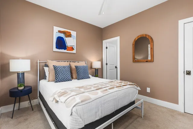 a bedroom with a bed and a painting on the wall