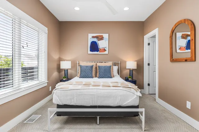 a large bed sitting in a bedroom next to a window