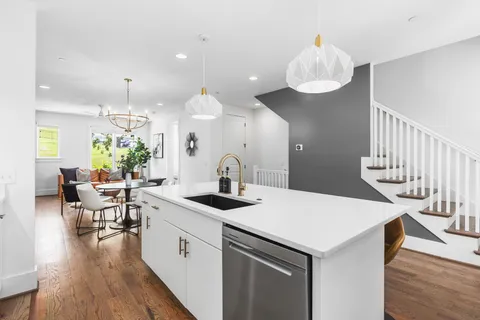 a kitchen with a table chairs and white cabinets
