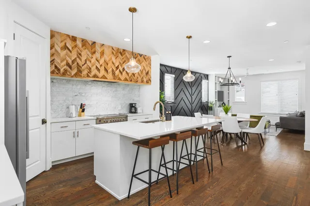 a kitchen with a table chairs stove and wooden floor