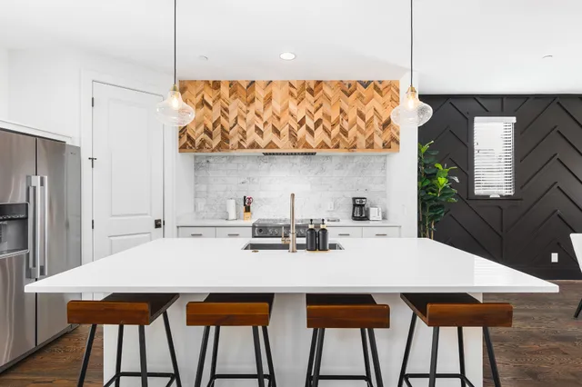 a kitchen with stainless steel appliances a sink a table and chairs