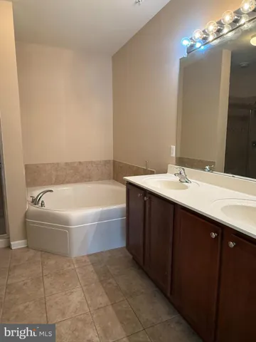 a bathroom with a tub a sink and mirror