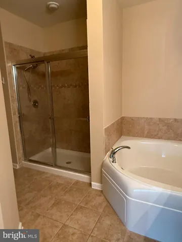 a white bath tub sitting next to a shower