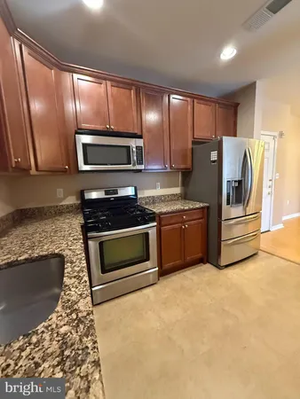 a kitchen with granite countertop stainless steel appliances and cabinets