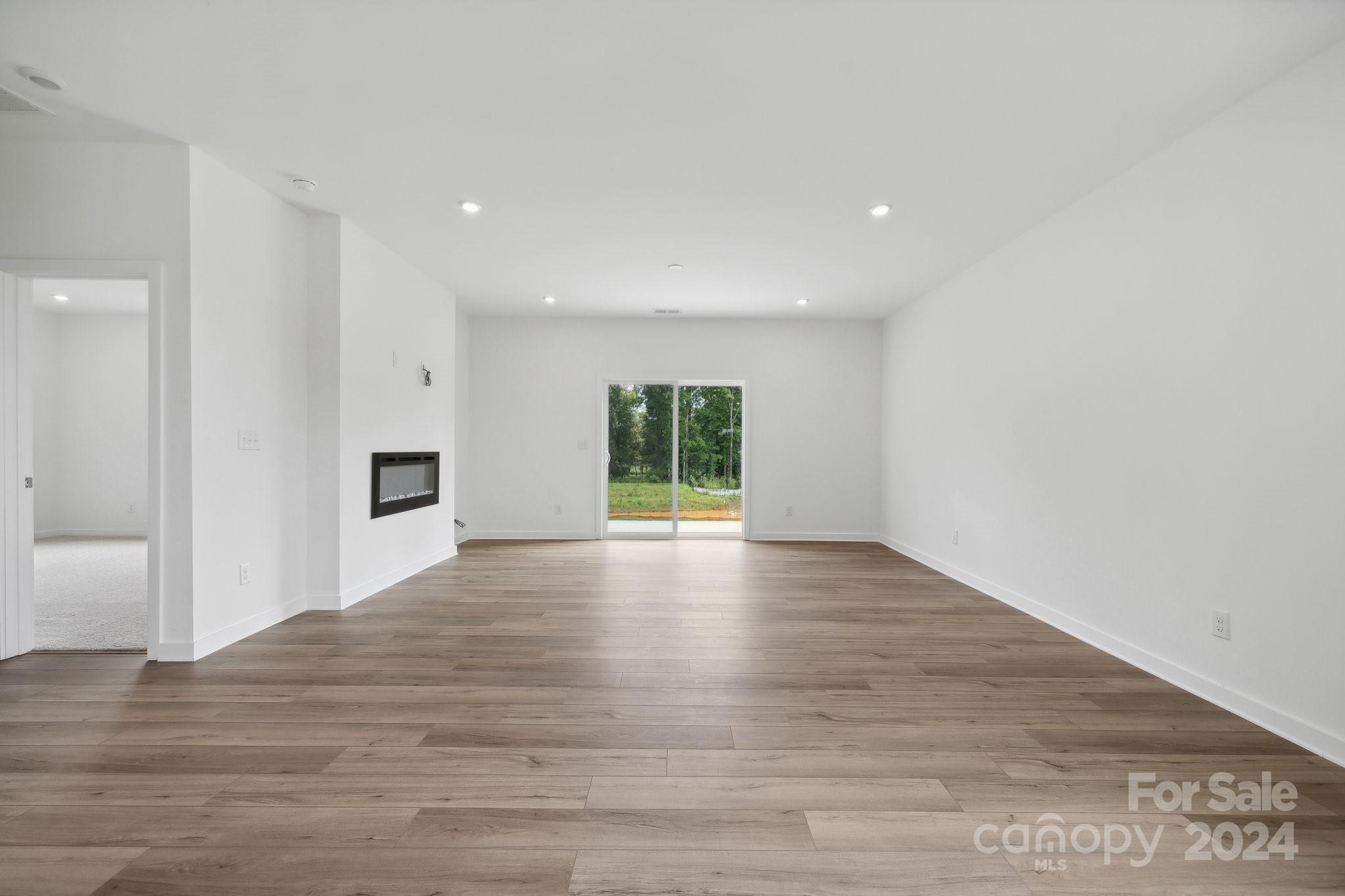 2568 Blue Sky Mdws Drive Monroe, NC 28110 - Photo 2 of 28 a view of empty room with wooden floor and fan