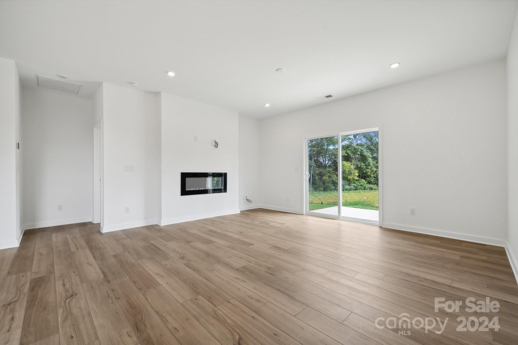 2568 Blue Sky Mdws Drive Monroe, NC 28110 - Photo 5 of 28 a view of empty room with wooden floor and floor to ceiling window