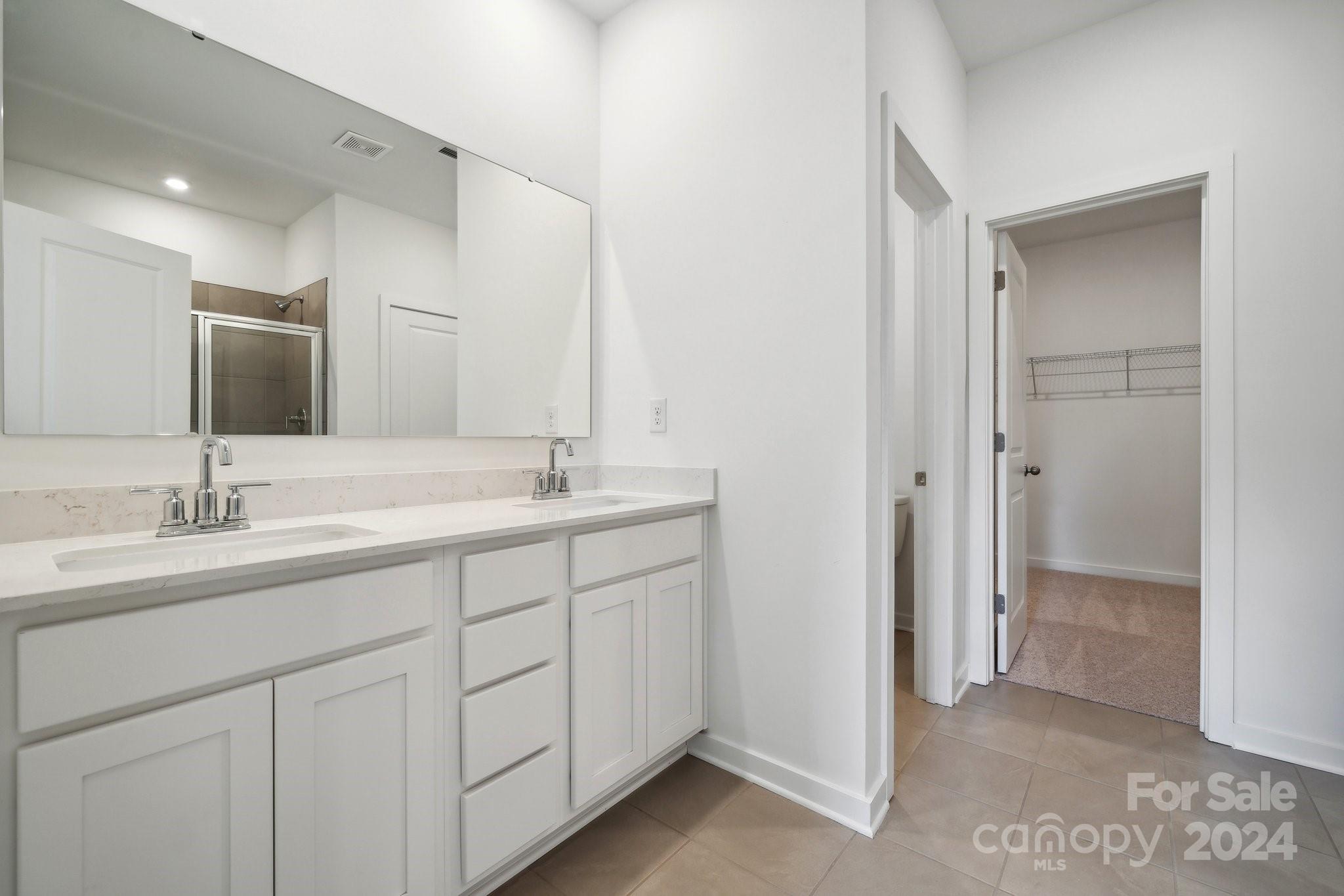 2568 Blue Sky Mdws Drive Monroe, NC 28110 - Photo 7 of 28 a bathroom with double sink and a mirror