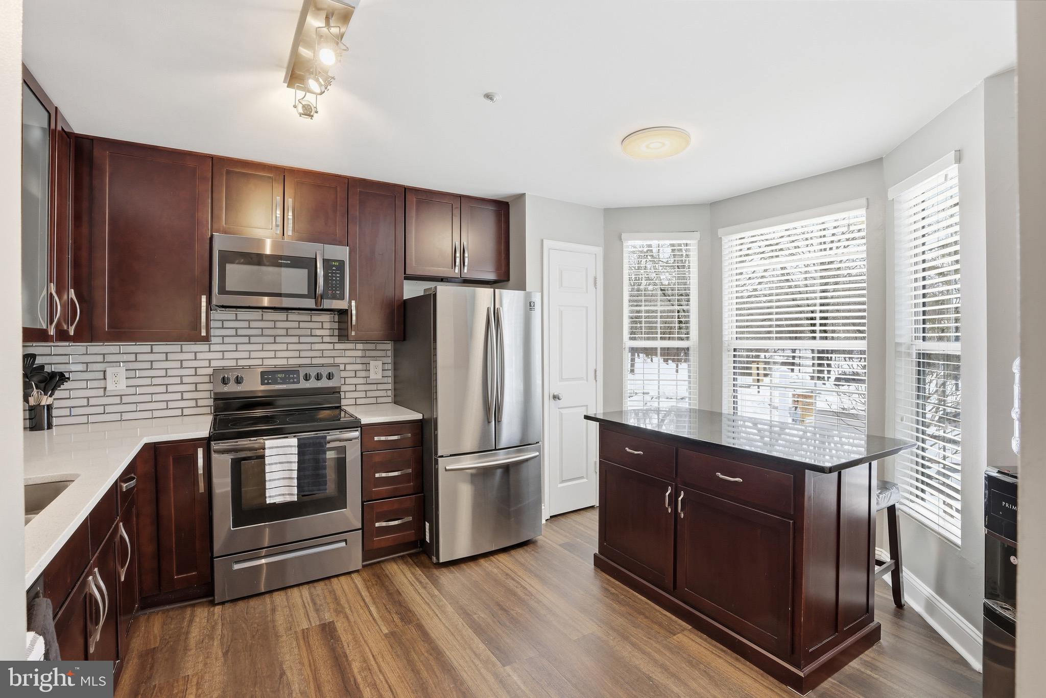 10724 Kitchener Court Bowie, MD 20721 - Photo 8 of 31 a kitchen with stainless steel appliances granite countertop a refrigerator a stove a sink and a microwave