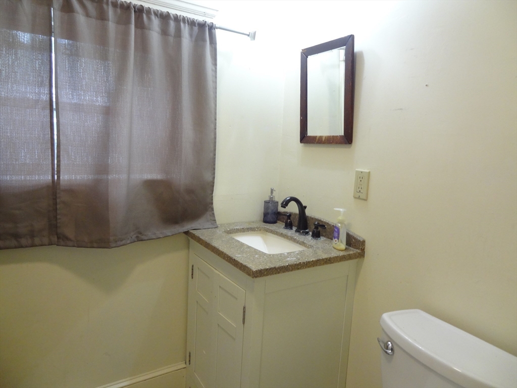 48 Maple Street, Unit 2 Holden, MA 01520 - Photo 15 of 17 a bathroom with a granite countertop sink and a mirror