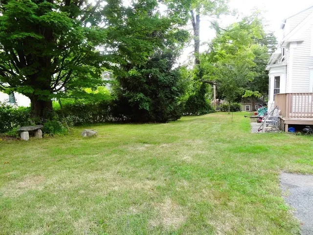 a view of green field with trees in the background