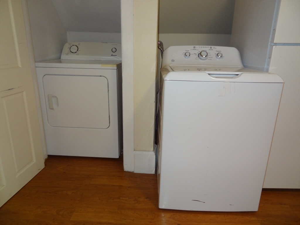48 Maple Street, Unit 2 Holden, MA 01520 - Photo 7 of 17 a view of washer and dryer with wooden floor