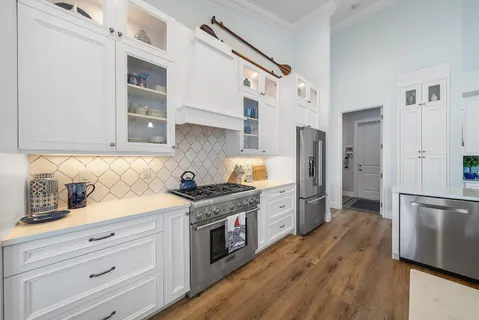 a kitchen with stainless steel appliances granite countertop a refrigerator and a stove top oven