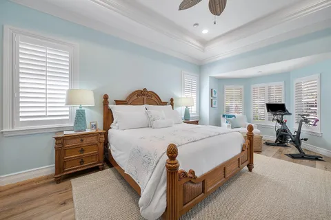 a spacious bedroom with a bed a dresser and window
