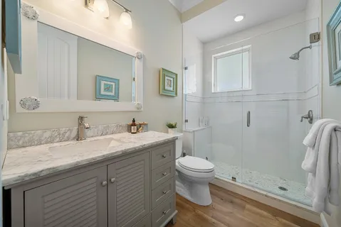 a bathroom with a granite countertop sink toilet and shower